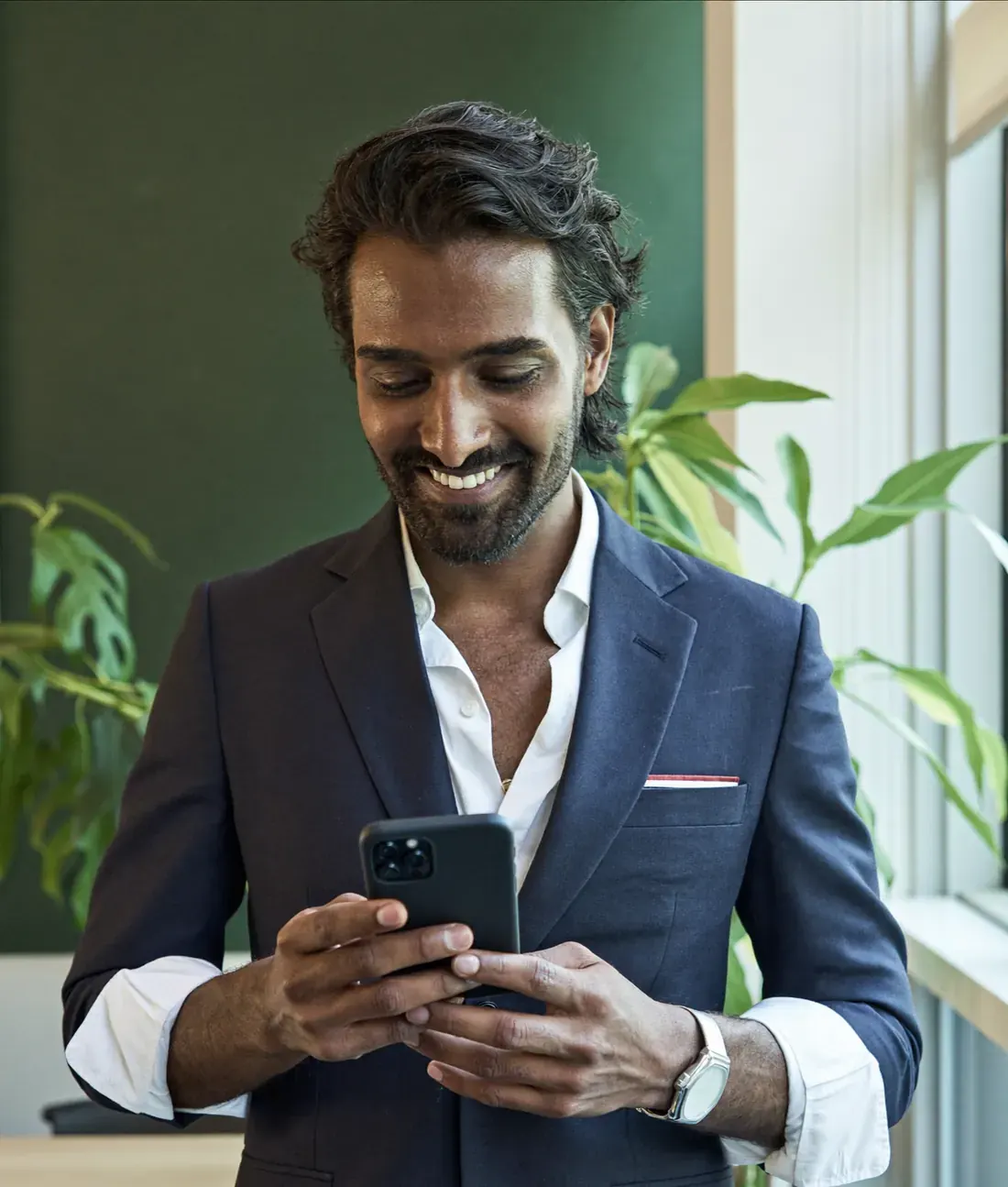 A founder smiling at his phone